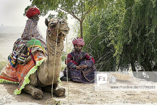 Männer der Dhebariya-Rabari-Gemeinschaft in traditioneller Kleidung mit einem Dromedar  Great Rann of Kutch Wüste  Gujarat  Indien  Asien