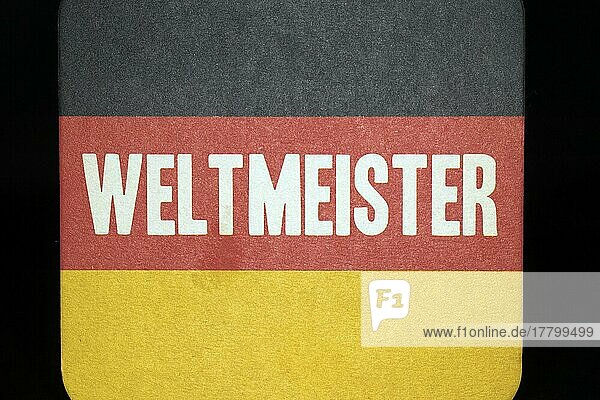 Bierdeckel mit der Aufschrift Weltmeister und den deutschen Nationalfarben  Studiofotografie mit schwarzem Hintergrund