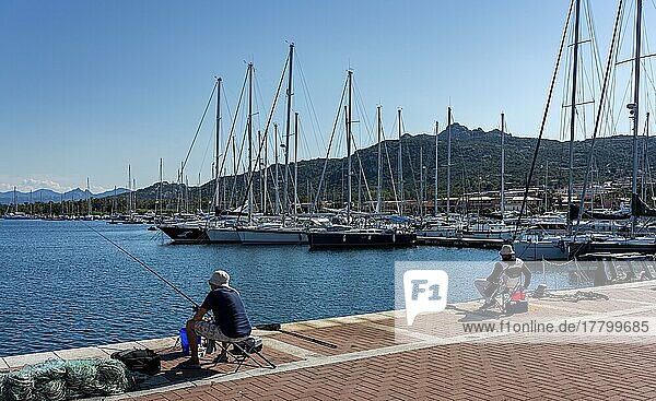 Anglers on the pier of a small marina in Sardinia  Italy  Europe