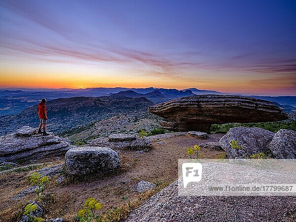 Wanderer steht bei der Felsformationen Sombrerillo aus Kalkstein bei Morgendämmerung  Naturschutzgebiet El Torcal  Torcal de Antequera  Provinz Malaga  Andalusien  Spanien  Europa