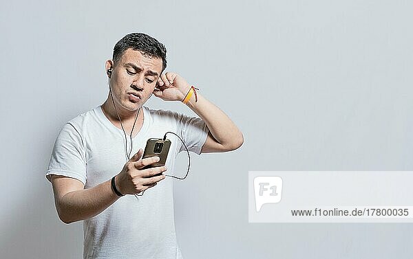 Handsome man listening to music with his cell phone with headphones isolated  people enjoying music with headphones isolated  cheerful guy listening to music with his cell phone isolated