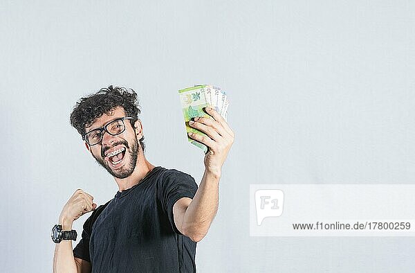 Aufgeregter Mann mit Geld in der Hand  glücklicher Mann  der Geldscheine in der Hand hält  Verdienst- und Sparkonzept