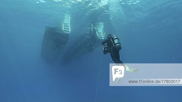 Scuba diver swim towards diving boat in blue water. Mediterranean Sea  Cyprus  Europe