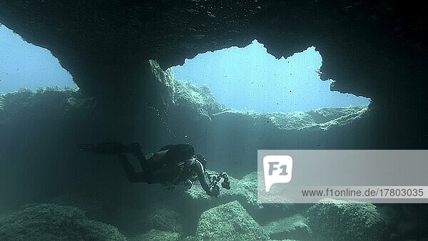 Scuba diver photographer swim in the cave. Cave diving in Mediterranean Sea  Cyprus  Europe