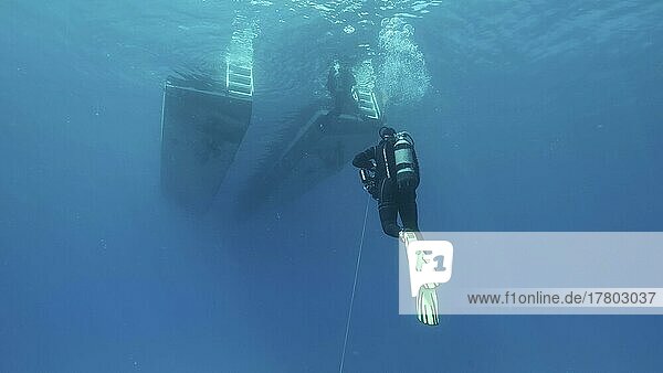 Scuba diver swim towards diving boat in blue water. Mediterranean Sea  Cyprus  Europe