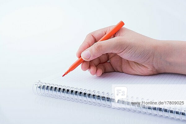 Handschrift auf einem Notebook mit einem Stift auf einem weißen Hintergrund