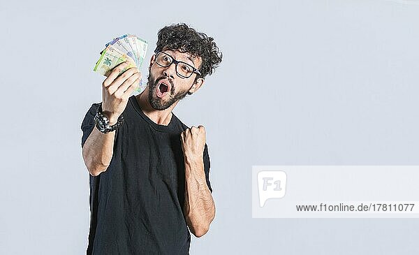 Glücklicher gutaussehender Mann mit Geld in der Hand  erstaunte Menschen mit Geldscheinen in der Hand  aufgeregte Person mit Geld in der Hand isoliert