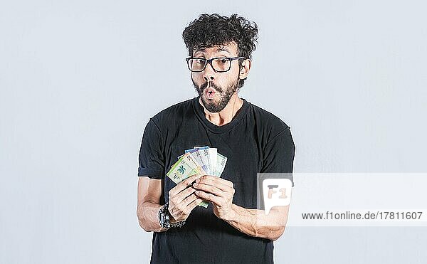 Aufgeregte Person mit Geld in der Hand isoliert. Glücklicher Mann mit Geld in der Hand  erstaunt Menschen mit Geldscheinen in der Hand