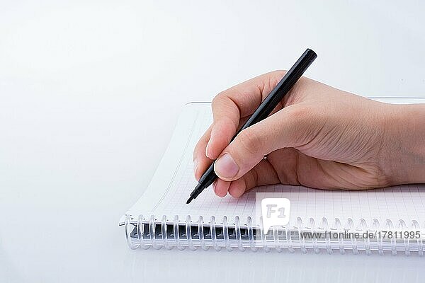 Handschrift auf einem Notebook mit einem Stift auf einem weißen Hintergrund
