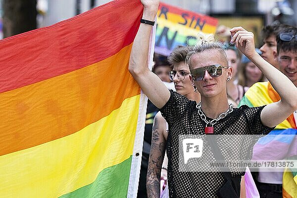 Junger homosexueller Mann trägr Regenbogenfahne auf der CSD Parade  Köln  Nordrhein-Westfalen  Deutschland  Europa