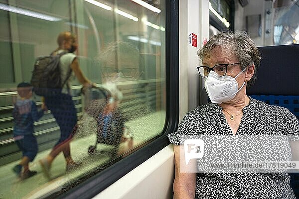 ältere Frau mit Mundschutzmaske  sitzt in S-Bahn  auf dem Bahnsteig Reisende  Sommerwelle  Corona-Krise  Stuttgart  Baden-Württemberg  Deutschland  Europa