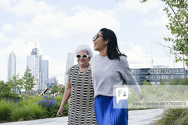 Glückliche ältere Frau und Tochter verbringen schöne Zeit beim Spazierengehen im Park