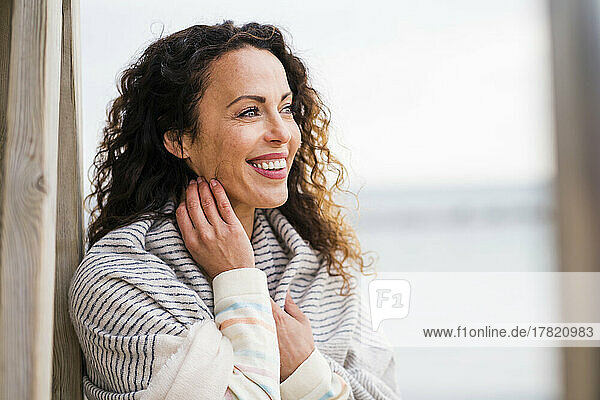 Happy woman with scarf touching neck