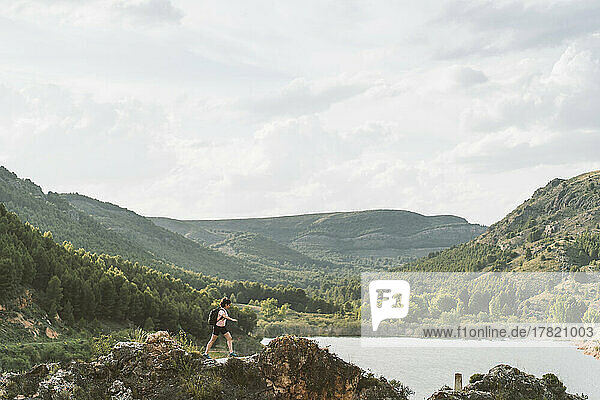 Woman walking on rock by lake in Aragon  Spain
