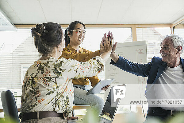 Erfolgreiche Geschäftskollegen geben sich im Büro gegenseitig High-Five