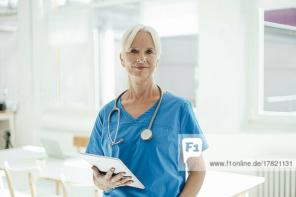 Smiling female doctor holding tablet PC