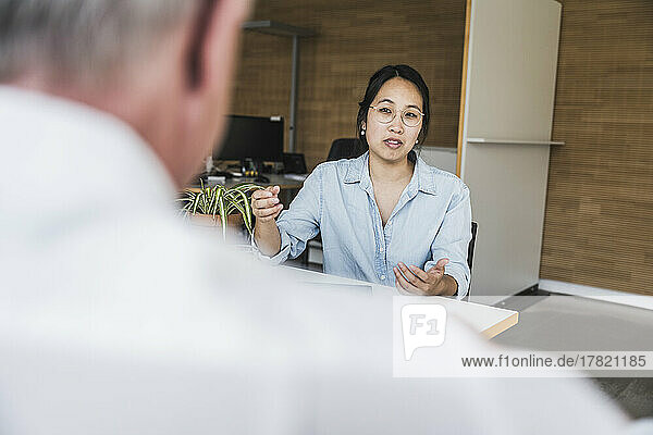 Businesswoman discussing work with colleague at work place