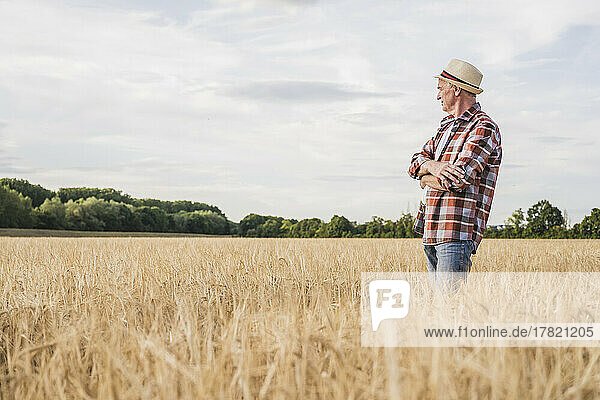 Farmer with arms crossed standing in farm