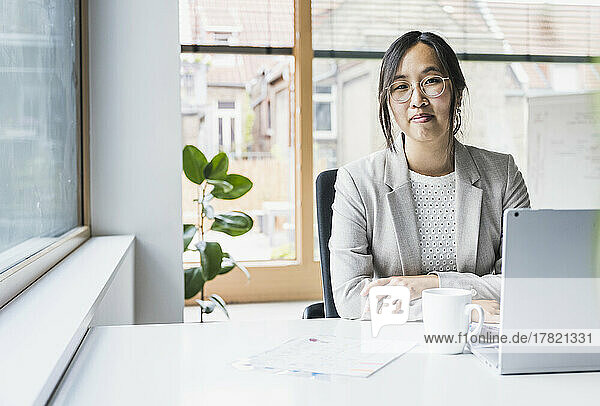 Smiling businesswoman sitting at desk in office