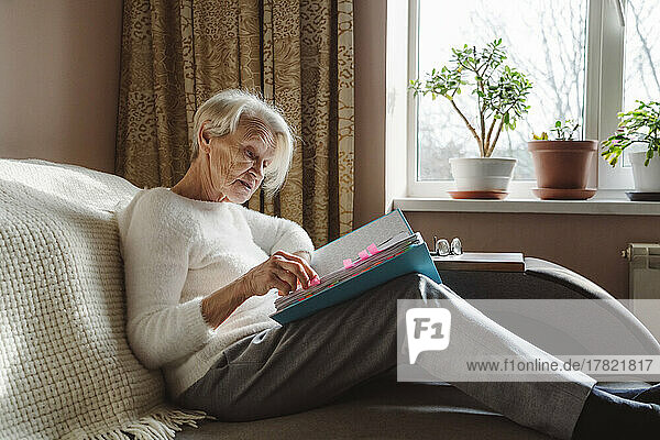 Senior woman reading documents at home