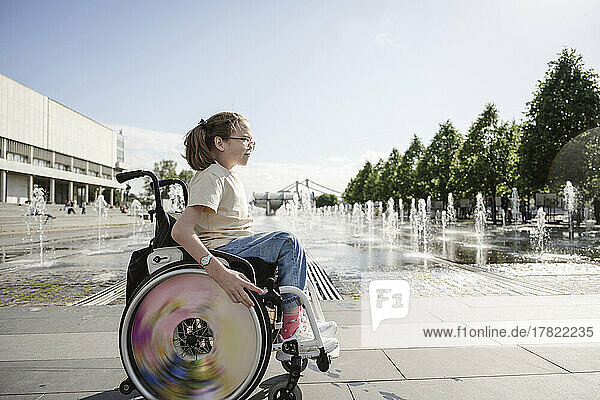 Girl sitting on wheelchair at park