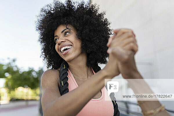 Happy Afro woman with rope holding hand of mother