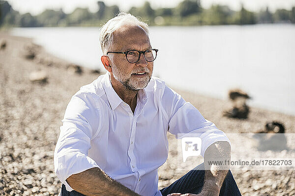 Älterer Mann mit Brille am Flussufer