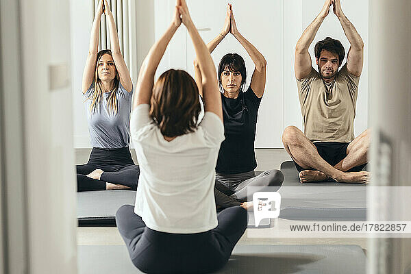 Lehrer unterrichtet Yoga-Kurs im Fitnessstudio