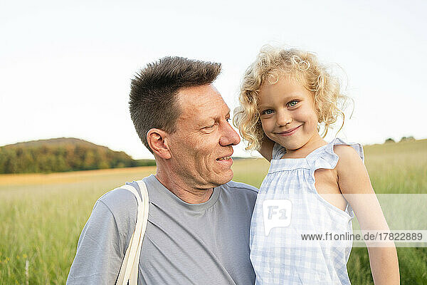 Smiling father looking at blond daughter