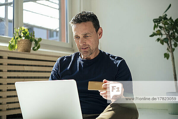 Businessman doing online banking through laptop at office