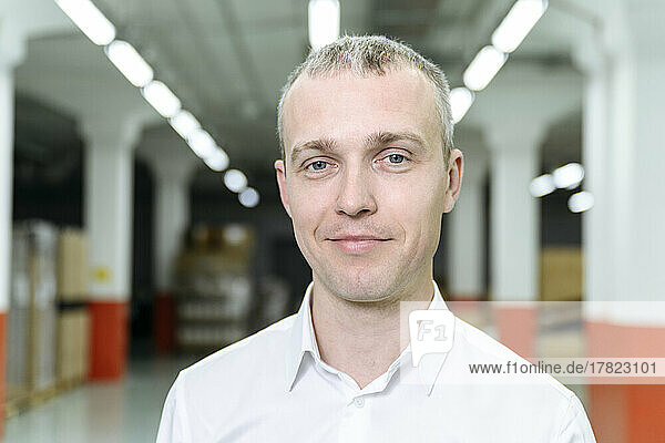 Smiling businessman in illuminated factory