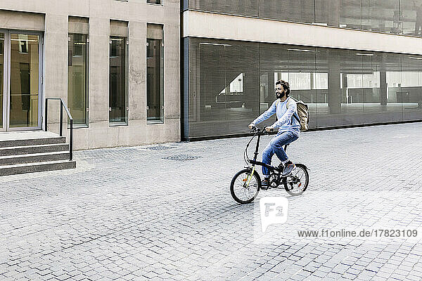 Lächelnder Mann fährt Fahrrad in der Stadt