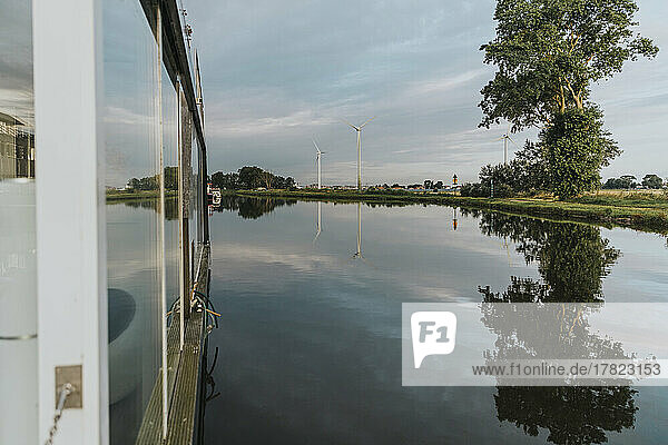 Houseboat on Yser River under cloudy sky