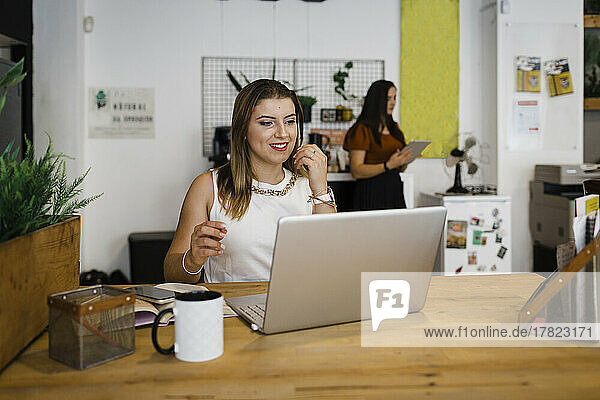 Happy businesswoman working on laptop in office