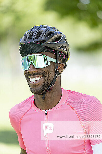 Smiling man wearing cycling helmet and sunglasses