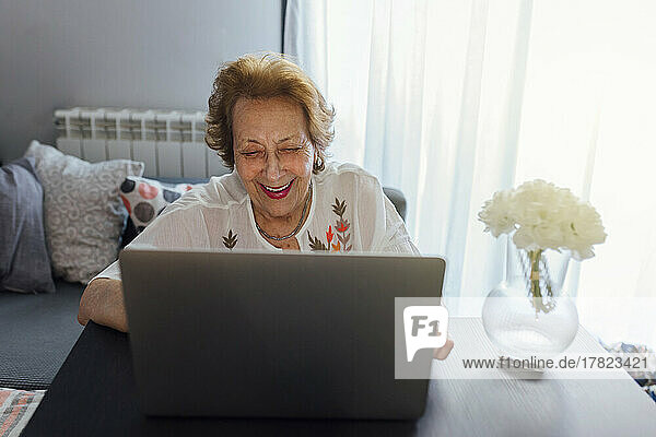 Smiling senior woman using laptop at home