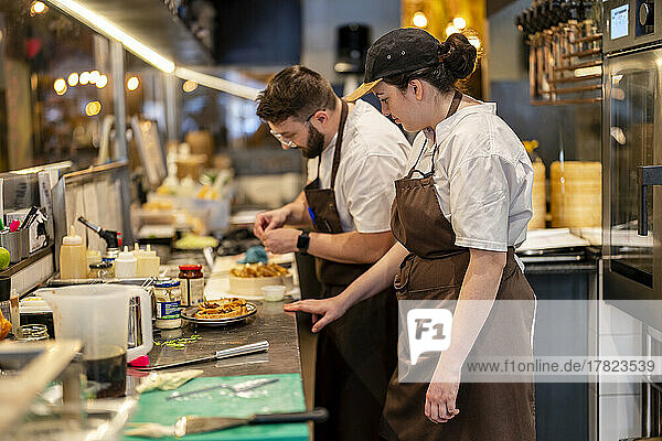 Chefs preparing food standing at restaurant kitchen