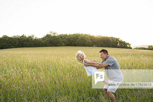 Father and daughter having fun in field