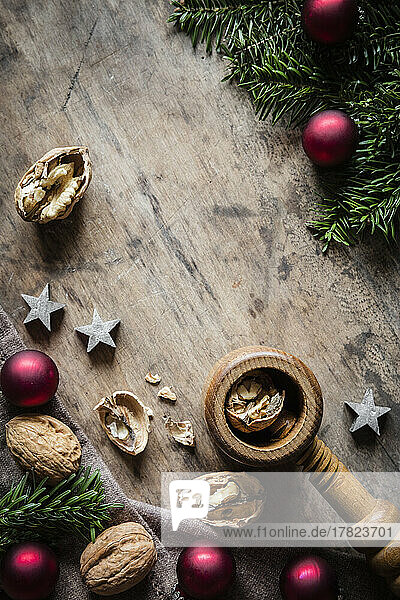 Studio shot of cutting board  twigs  Christmas ornaments  walnuts and simple nutcracker