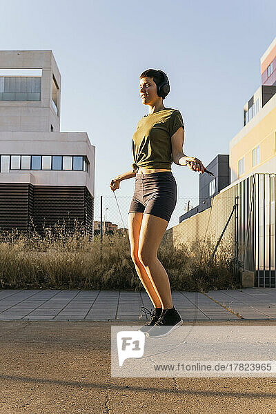 Woman practicing jump roping on sunny day