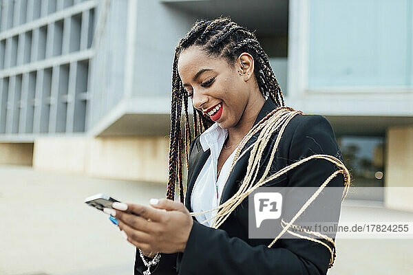 Happy young businesswoman using mobile phone