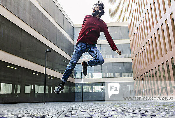 Smiling man jumping over street