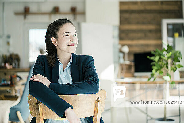 Thoughtful businesswoman sitting on chair in office