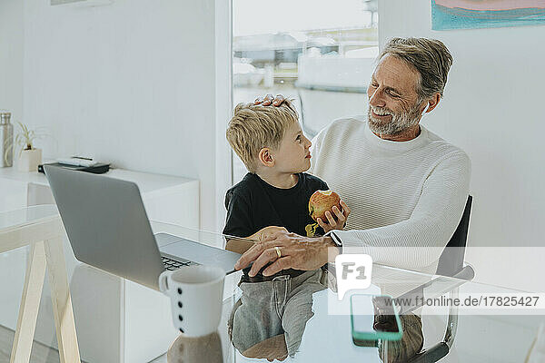Happy father with son sitting at table