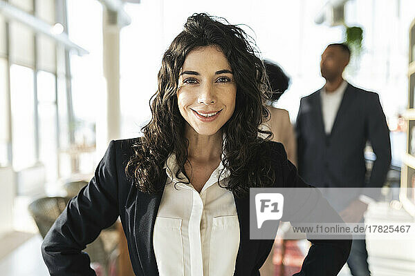 Confident businesswoman with long hair standing at office