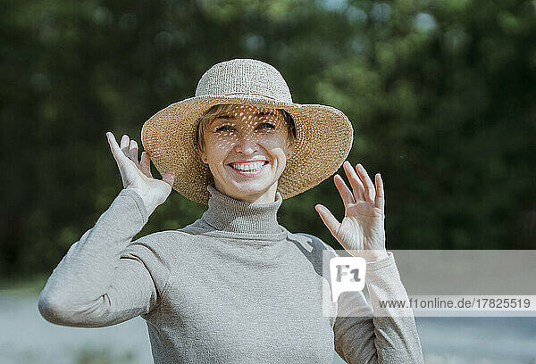 Smiling woman wearing hat enjoying sunny day
