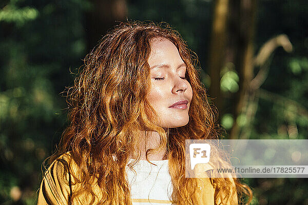 Redhead young woman enjoying sunlight
