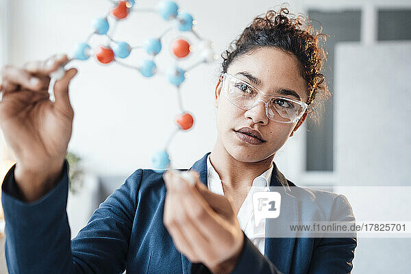 Businesswoman examining molecular structure in office