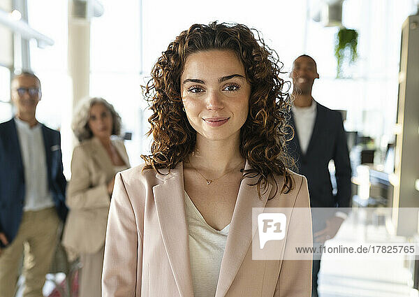 Smiling businesswoman with curly hair at office
