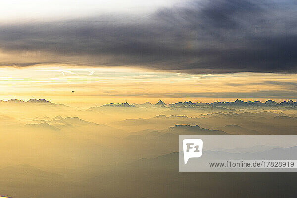 Flug über die majestätischen Schweizer Alpen in einem Meer von Wolken bei Sonnenuntergang  Schweiz  Europa